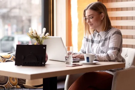 Digitale Nomaden beim mobilen Arbeiten mit Laptop im Café